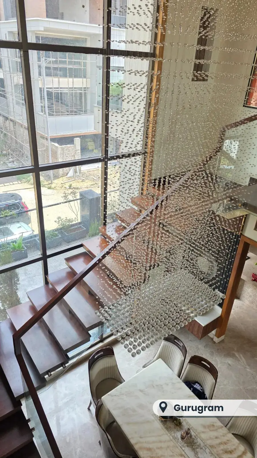 Cantilevered wooden staircase in a double-height hall, Gurugram