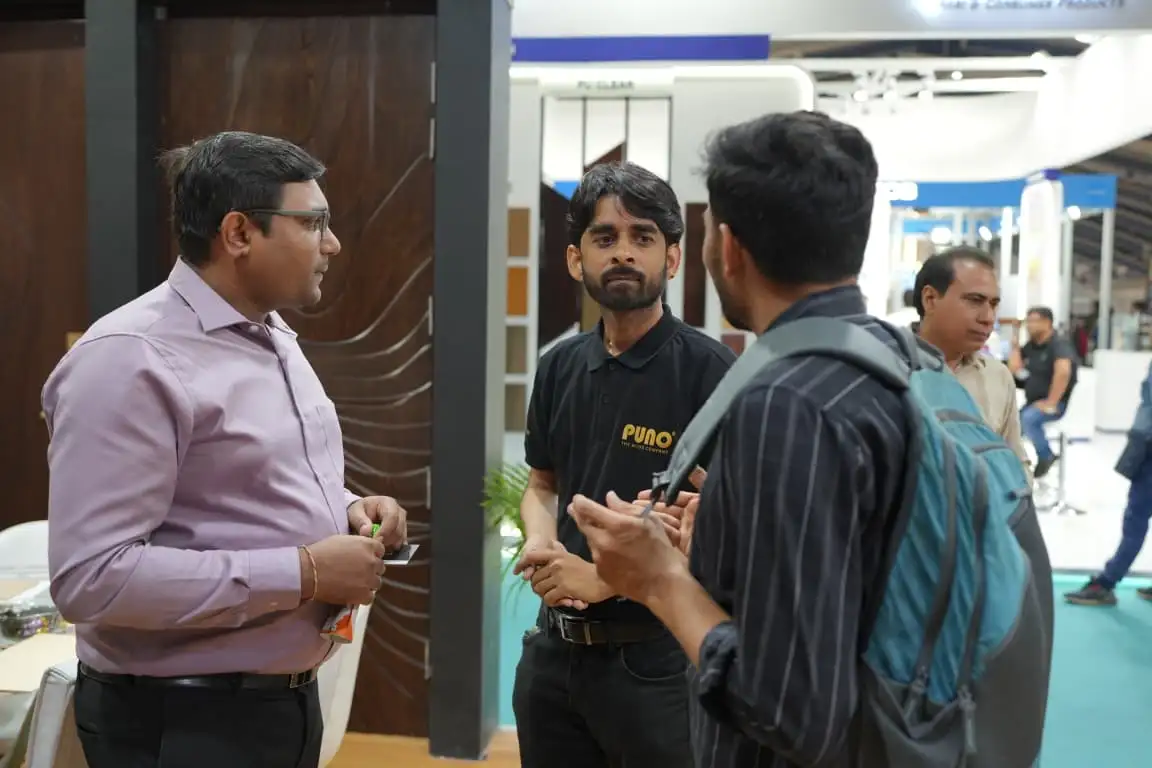 Puno team member in conversation with visitors beside a wooden door display