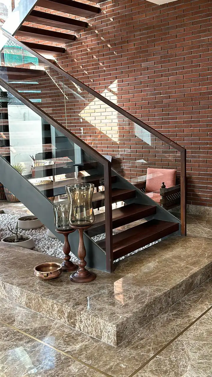 Underside of a wooden staircase against a brick wall
