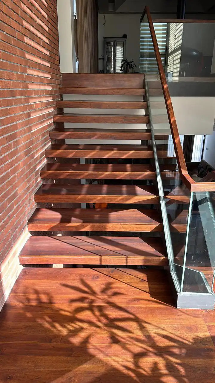 Floating wooden treads against an exposed brick wall