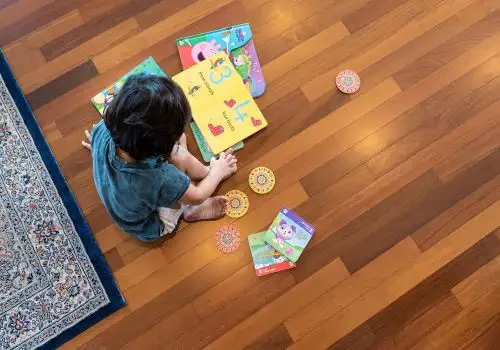 Child reading on a warm wooden floor